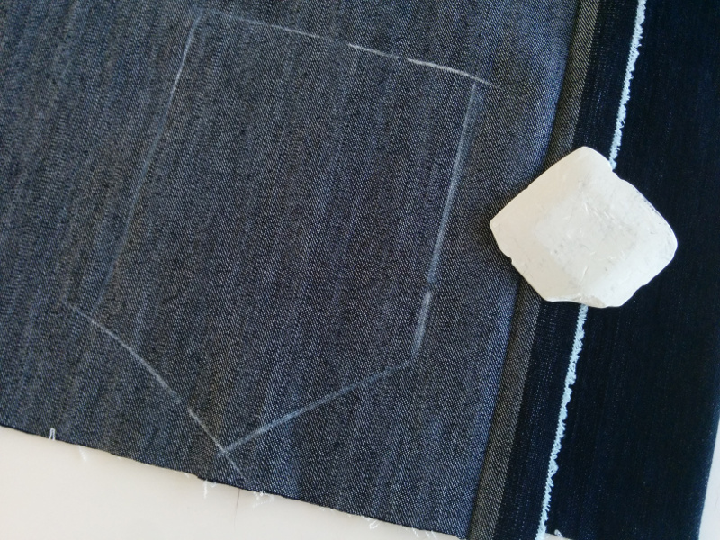 A pocket is marked on the bad side of a piece of double-folded denim, ready
to be cut good sides together. After cutting both layers, this will yield two
pockets that are mirror images of each other.